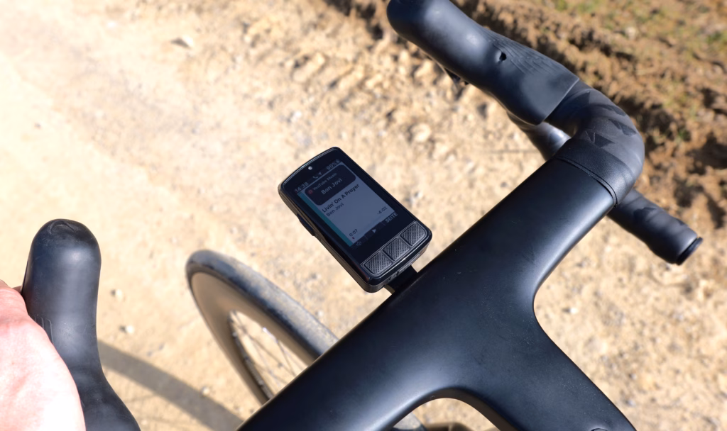Wahoo ELEMNT BOLT V3 on a road bike handlebar showing music controls during a ride.