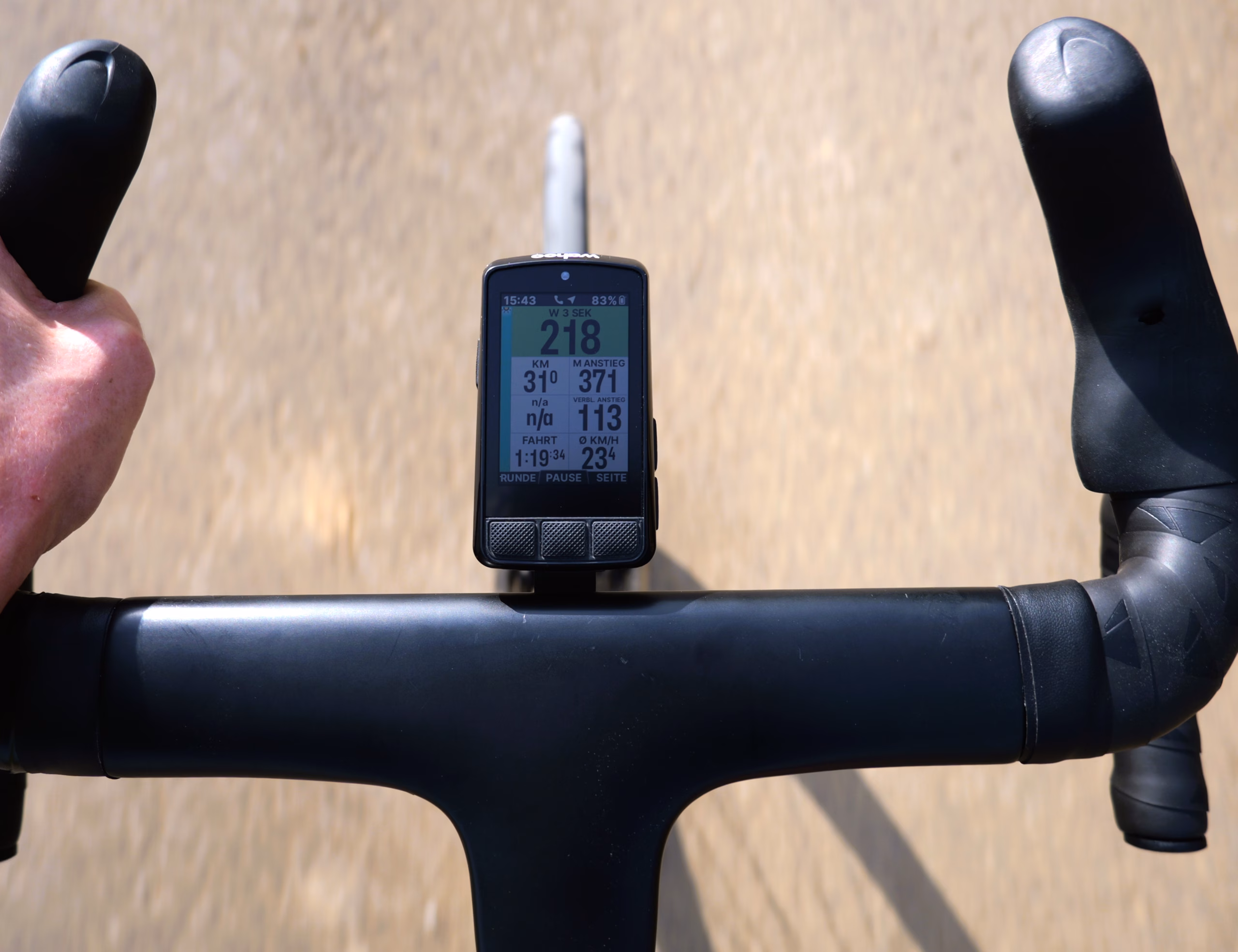 Wahoo ELEMNT BOLT V3 on a road bike handlebar with a green power zone on the display