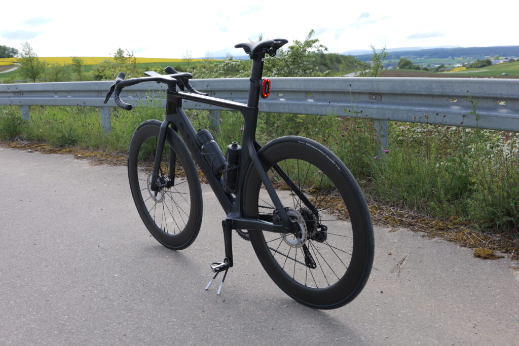 Canyon Aeroad road bike with an iGPSport SR Mini rear light fitted to the seatpost against a landscape backdrop.
