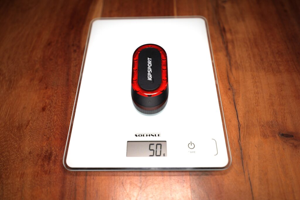 iGPSPORT SR Mini on a kitchen scale showing 50 grams.