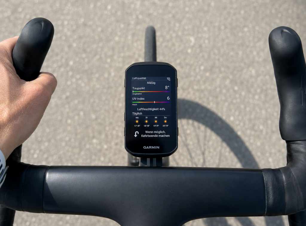 Garmin Edge 850 on a bicycle handlebar displaying air quality, dew point, UV index, humidity and an instruction to make a U-turn when possible.