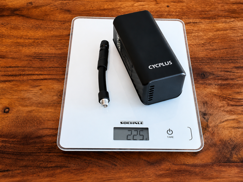 CYCPLUS A3 Mini electric bike pump with air hose on a digital scale showing 225 grams.
