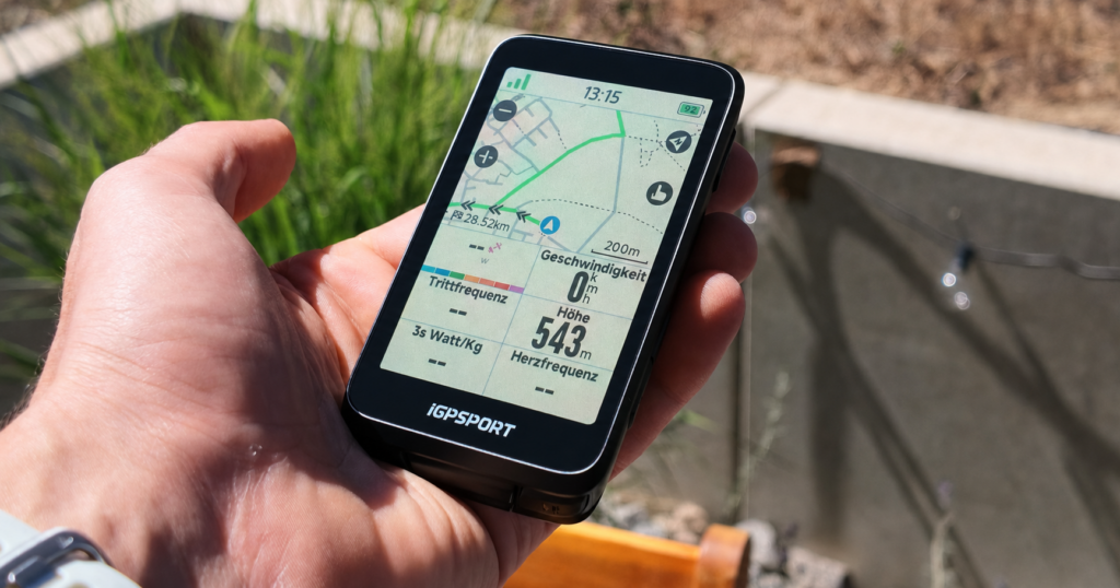 The Image Shows an iGPSPORT BiNavi Bike Computer with Its Display Being Tested in Sunshine