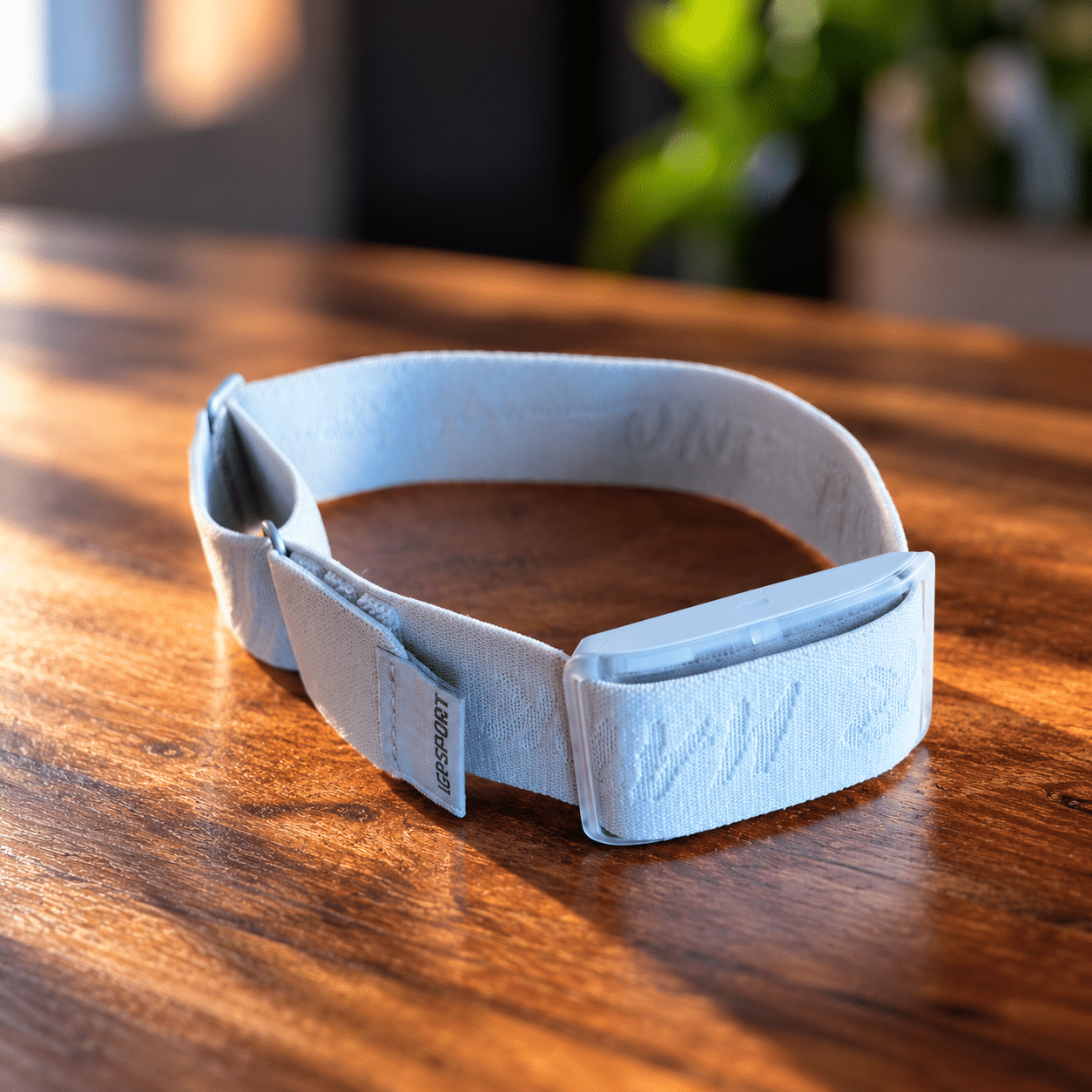 iGPSPORT HR80 Heart Rate Sensor with a Light Blue Upper-Arm Strap on a Wooden Table