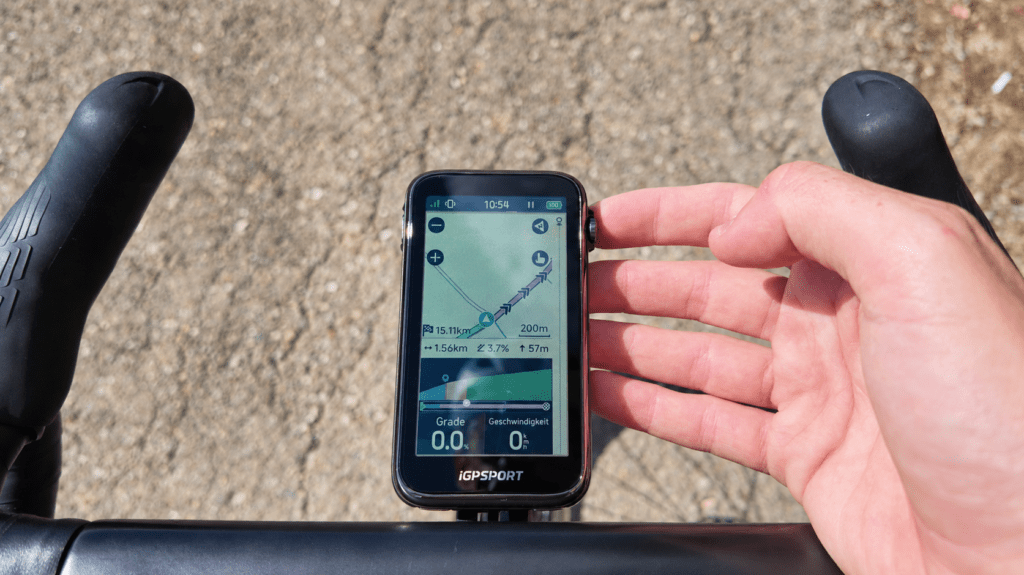 iGPSPORT BiNavi Ultra with a Colour Map View and a Hand on the Scroll Wheel