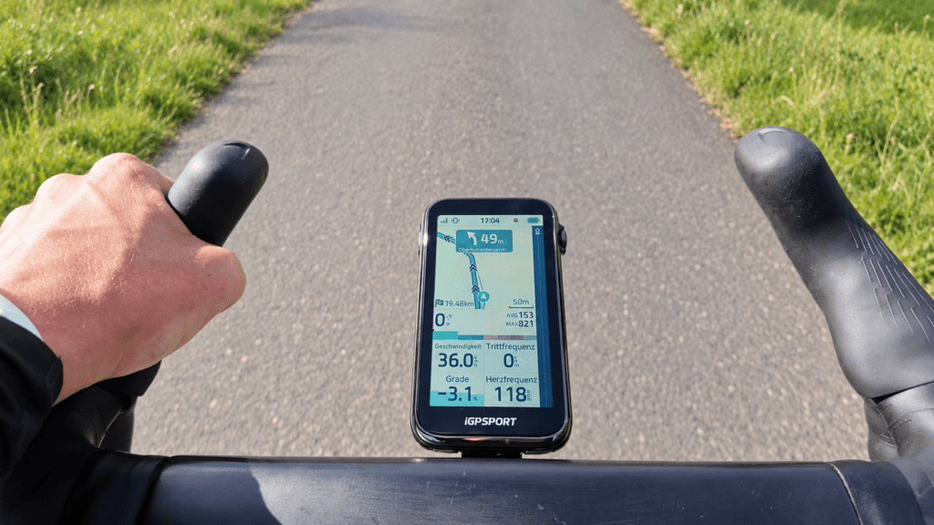 iGPSPORT BiNavi Ultra with map navigation on a road bike handlebar while riding